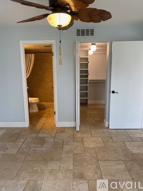 A room with a ceiling fan and a tiled floor.