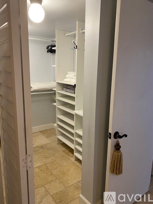 A room with a bed and a closet with shelves.