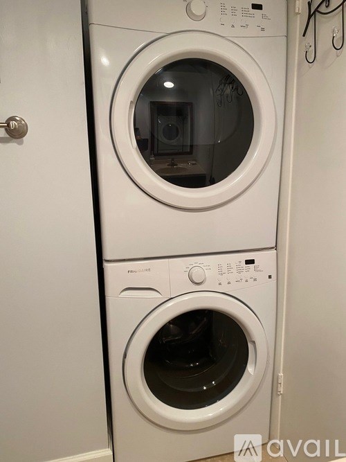 A white front loading washing machine with a dryer on top.