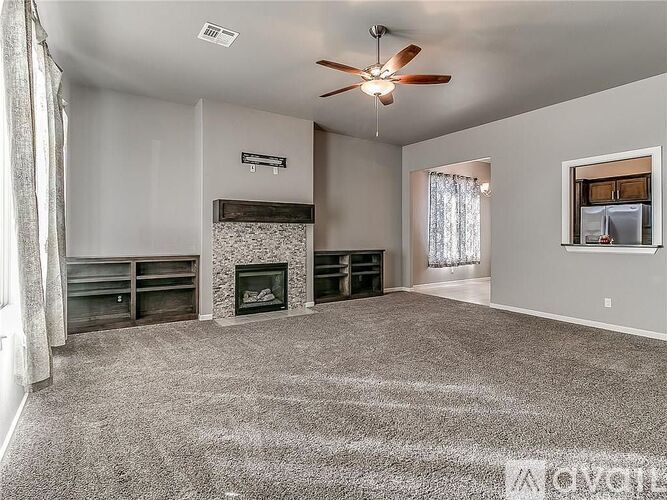 A living room with a fireplace and a ceiling fan.