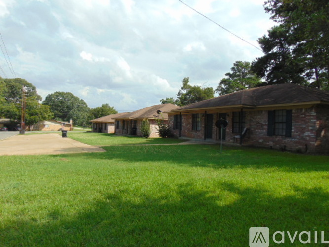 A grassy area in front of a house with a sign that says "AVAIL".