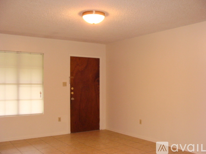 A room with a brown door and a window with blinds.
