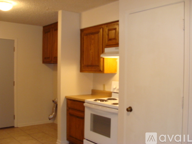 A kitchen with a stove and wooden cabinets.
