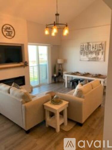 A living room with a couch, a coffee table, and a television.