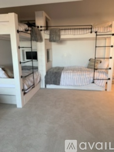 A bedroom with two bunk beds and a small TV.