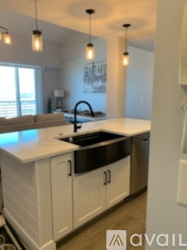A kitchen with white cabinets and a black sink.