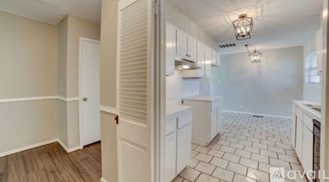 A kitchen with white cabinets and a tiled floor.