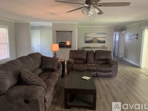 A living room with a brown sofa and a coffee table.