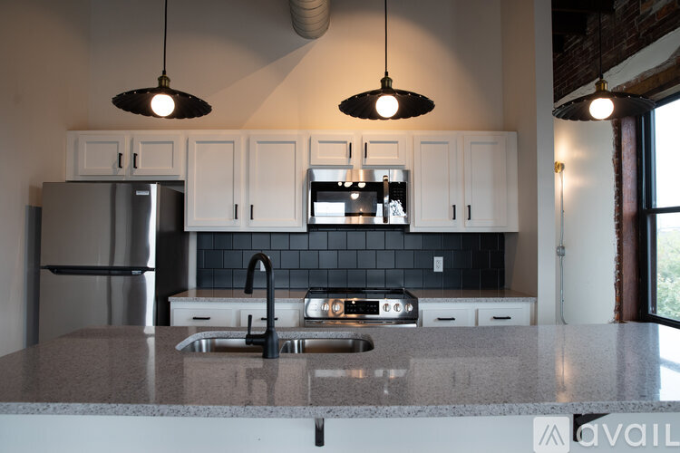 A kitchen with a granite countertop and white cabinets.