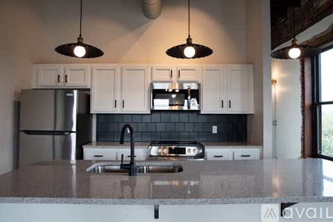 A kitchen with a granite countertop and white cabinets.