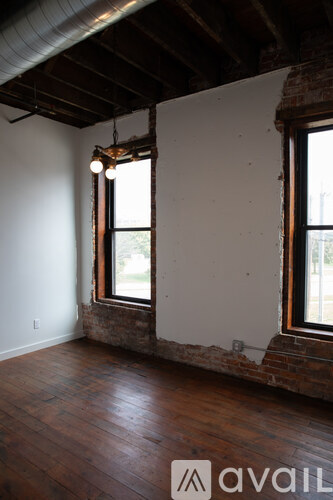 A room with wooden floors and exposed brick walls.