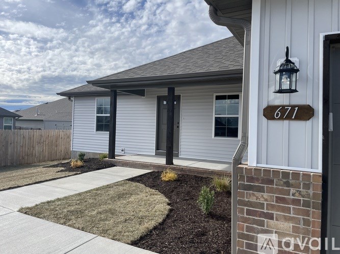 A house numbered 671 with a black door and a grey roof.