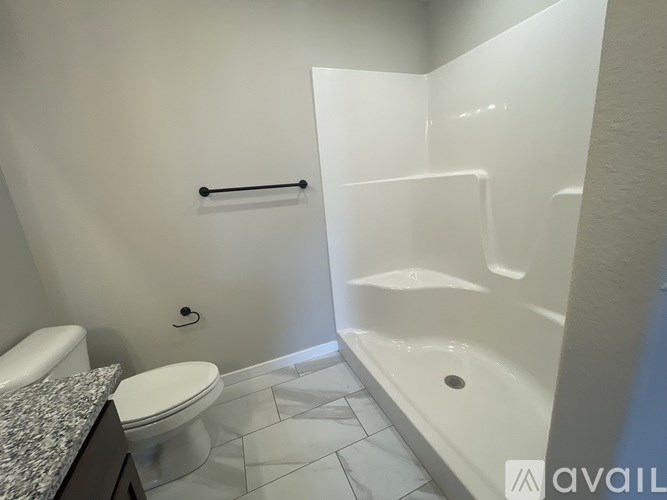 A white bathroom with a toilet, sink, and bathtub.