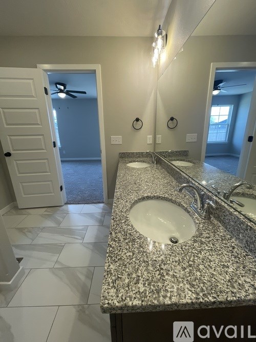 A bathroom with a granite countertop and a white sink.