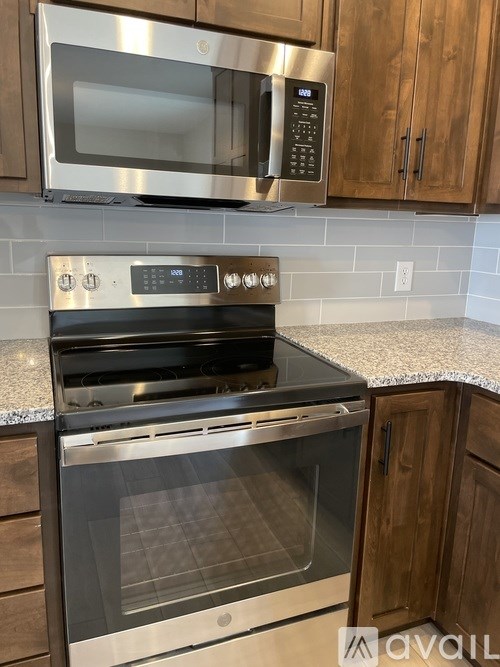 A stainless steel oven with a digital display is built into a kitchen countertop.
