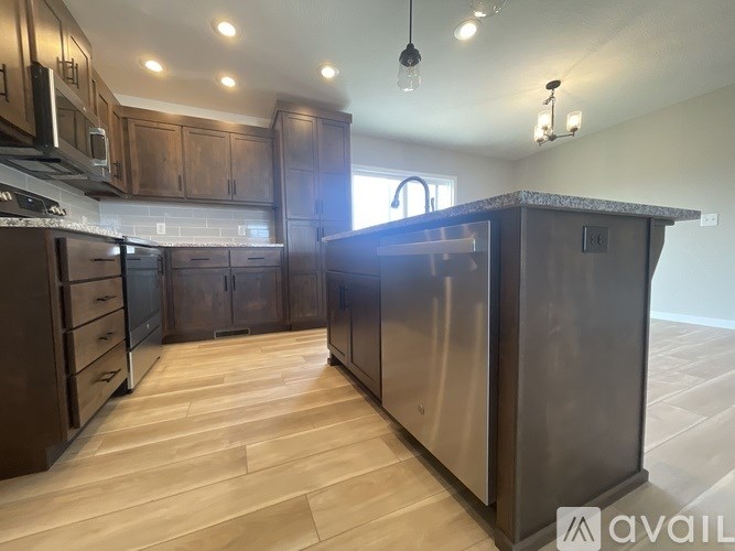 A kitchen with wooden cabinets and a granite countertop.