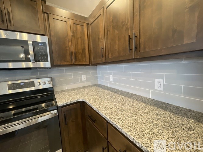 A kitchen with a granite countertop and stainless steel appliances.