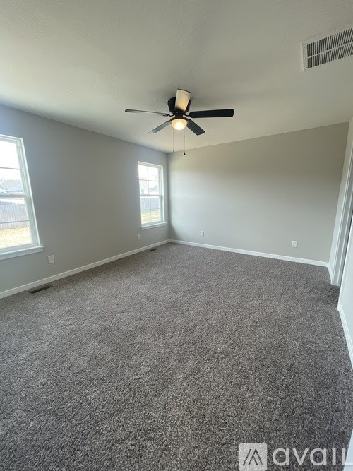 A room with a ceiling fan and carpeted floor.