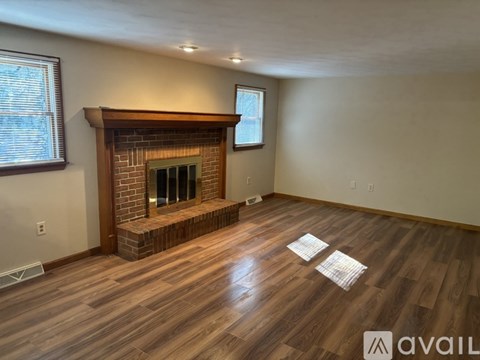 A living room with a fireplace and wooden floors.