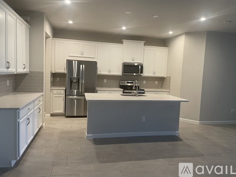 A modern kitchen with white cabinets and stainless steel appliances.