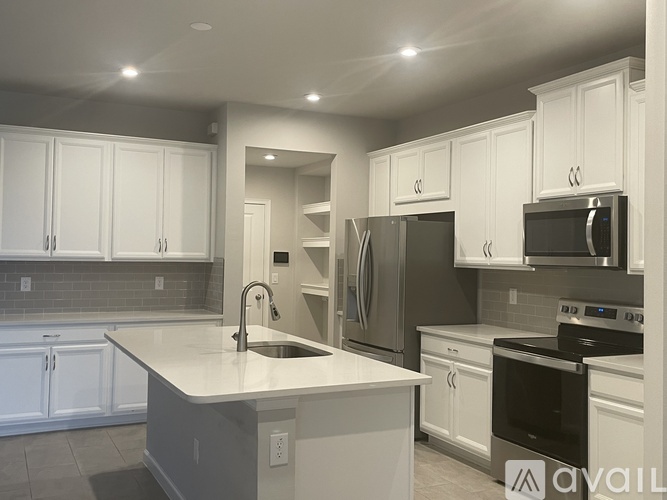 A modern kitchen with white cabinets and stainless steel appliances.