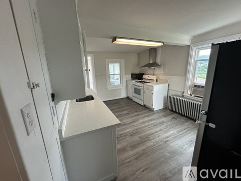 A kitchen with white cabinets and a white fridge.