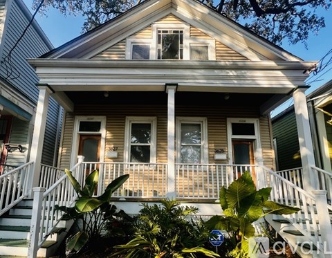 A house with a porch and a front yard with plants.