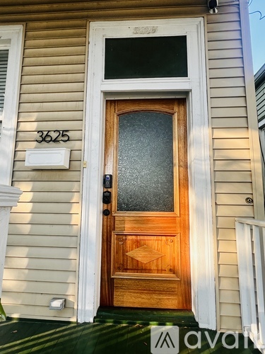 A wooden door with a glass panel and a number 3625 on the wall above it.