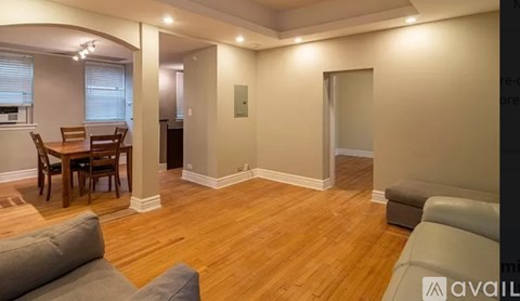 A living room with a grey couch and a wooden dining table.