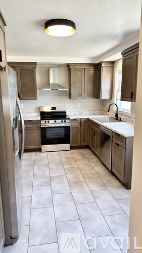 A kitchen with a refrigerator, stove, and sink.