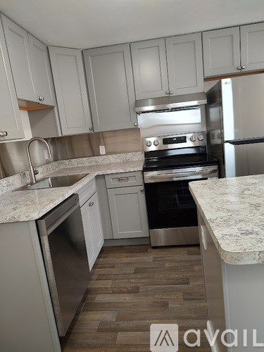 A kitchen with a stove top oven and a refrigerator.