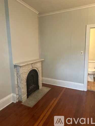 A room with a fireplace and wooden floors.