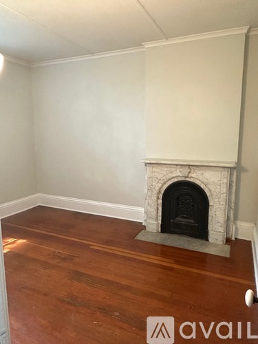 A room with a fireplace and wooden floors.