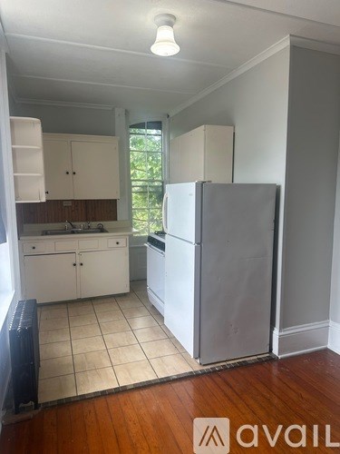A kitchen with white cabinets and a refrigerator.