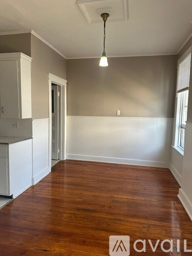 A room with wooden floors and a white cabinet.