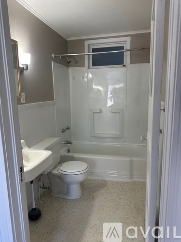 A bathroom with a toilet, sink, and bathtub.