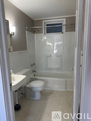 A bathroom with a toilet, sink, and bathtub.
