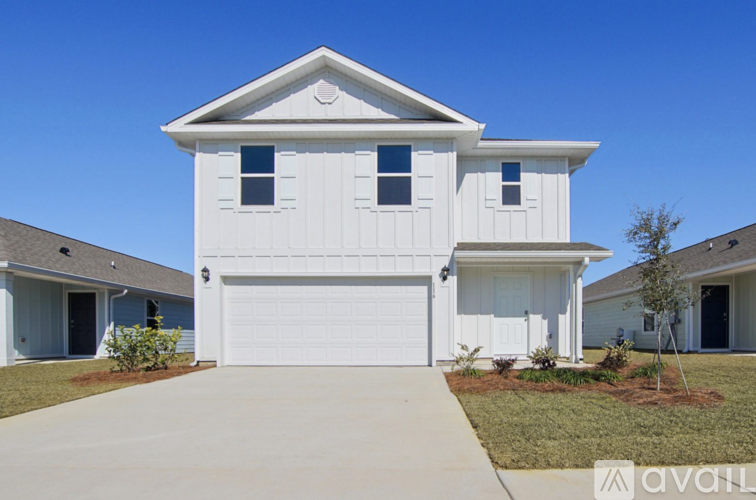 A white house with a garage door in the front.