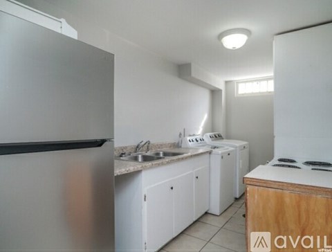 A kitchen with white cabinets and a stainless steel refrigerator.