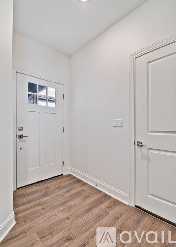 A hallway with a white door and a window.