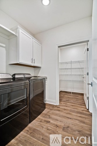 A kitchen with white cabinets and a black oven.