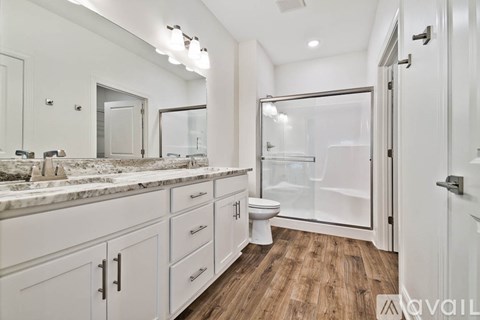 A bathroom with a marble countertop and white cabinets.