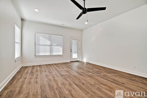 A room with wooden flooring and a ceiling fan.