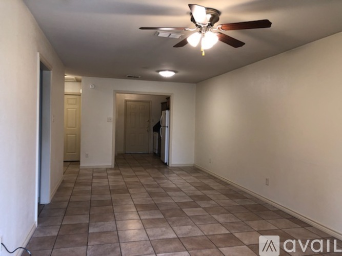 A room with a ceiling fan and tile flooring.