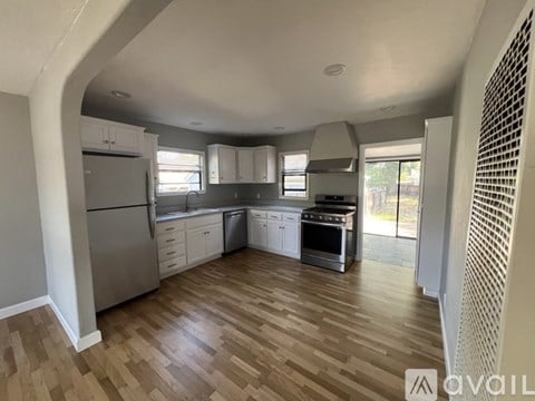 A kitchen with wooden floors and stainless steel appliances.