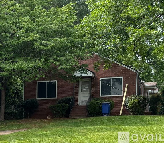 A red brick house with a green lawn in front.