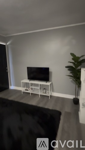A black flat screen TV on a white stand in a room.