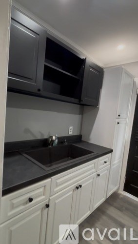 A kitchen with white cabinets and a black countertop.