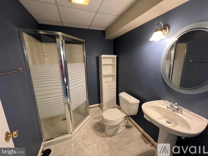 A bathroom with a toilet, sink, and shower.