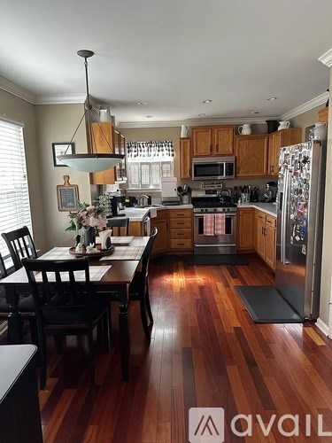 A kitchen with wooden floors and a table set for two.